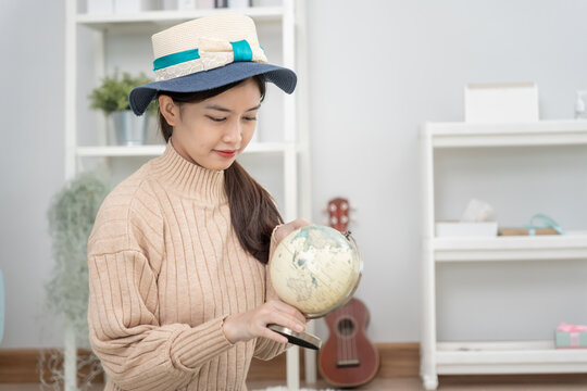 Traveler, travel bag.Asian female are look on orb and choose country for travel. Young women are prepare clothes and personal belongings. Pack your luggage before travel, Travel, life style