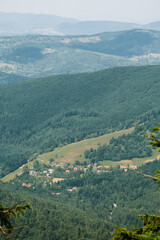 Fototapeta premium Mountain valley with forest hills and distant village Polish landscape photography