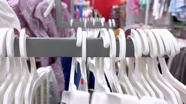 Close up of white hangers on clothing rack in store