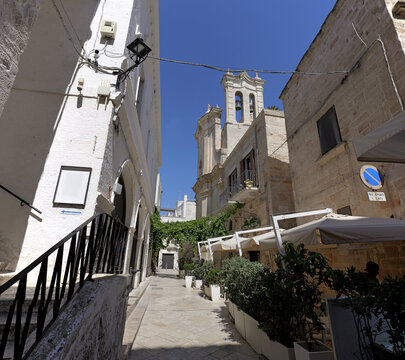 Historic street with church bell tower in polignano a mare