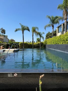 Luxury private infinity pool overlooking the Mediterranean Sea, lush greenery, elegant villa, crystal-clear water, golden sunset