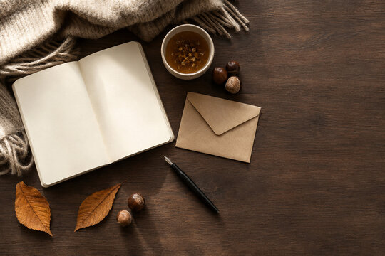 Cozy autumn writing desk with blank notebook and copy space