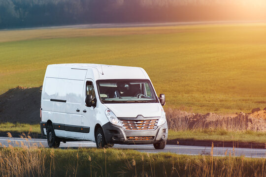 Modern white van moving through peaceful green countryside