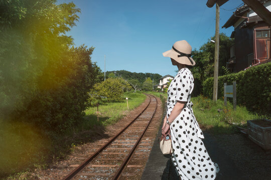 Woman Waiting at Rural Railway Platform