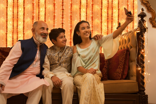 children clicking selfie with their grandfather on Diwali