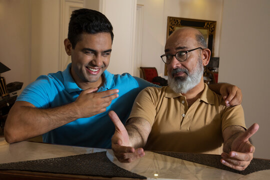 Father and son having fun with each other in the living room (Family)