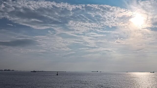 Scenic coastal seascape with navigation marker and cargo ships for shipping logistics and marine safety project