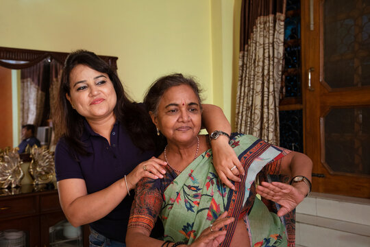 Daughter-in-law dancing in the living room with her mother-in-law at home 