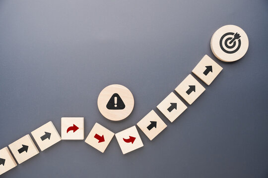 Wooden arrows changing direction to avoid risks while staying on course toward a target, illustrating strategic planning, risk management, resilience, business success and goal achievement