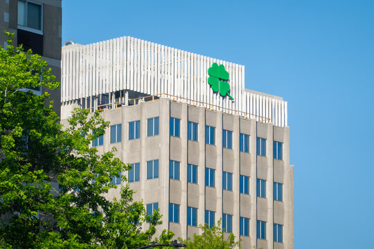Montreal, Quebec, Canada. July 30, 2026. Low angle shot of city hall building featuring green Ville de Montreal rosette logo against blue sky.
