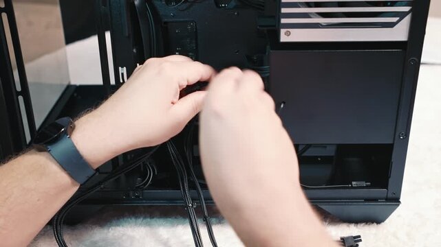 Connecting power cable to computer power supply unit, careful connection of power cable inside the case during personal computer assembly and cable management