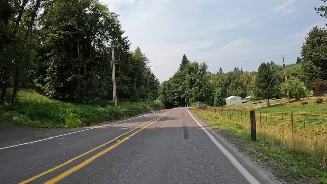 4K smooth stabilized action camera footage driving along scenic rural countryside roads in Washington, USA through evergreen forests, open fields and quiet residential farmland from a driver's p.o.v