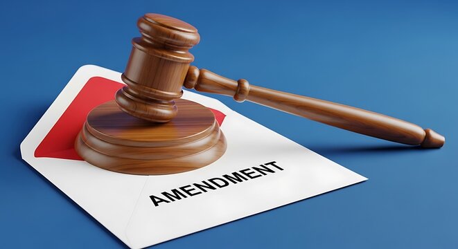 A wooden gavel rests on a white envelope labeled "Amendment" with a red inner lining, on blue background