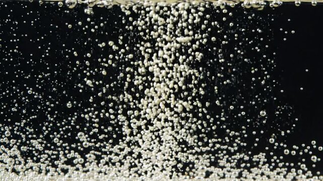 Bubbles rising in dark water, abstract background, motion, splash