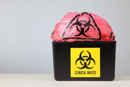 Alarming clinical waste management container with biohazard medical disposal bag represents serious environmental hazard