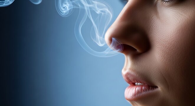Close-up of a person's nose and mouth with wisps of smoke emanating from nostrils