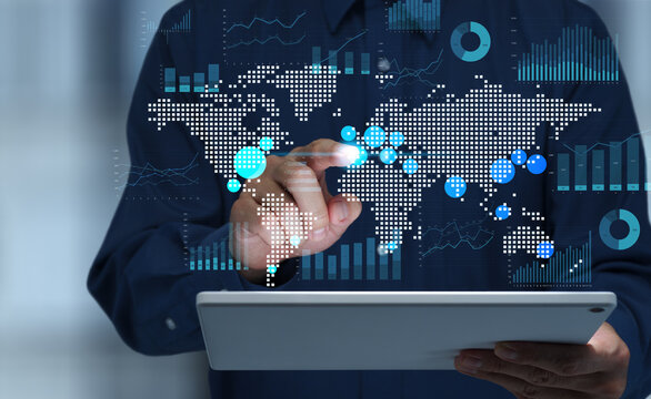 Global business and data analysis. Analytics dashboard for international market trends and growth opportunities. Businessman tapping world map with charts and graphs on digital tablet.