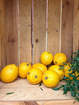 Fresh yellow lemons in a rustic wooden crate. Fresh summer background