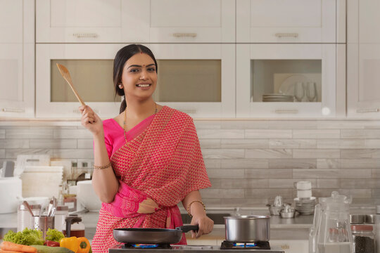 woman in saree standing with saute paddle