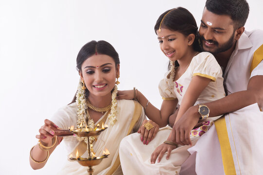 woman lighting lamp with a diya