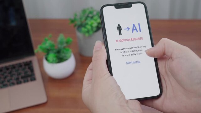Person views an AI adoption required notification on a phone, prompting employees to begin using artificial intelligence at work.