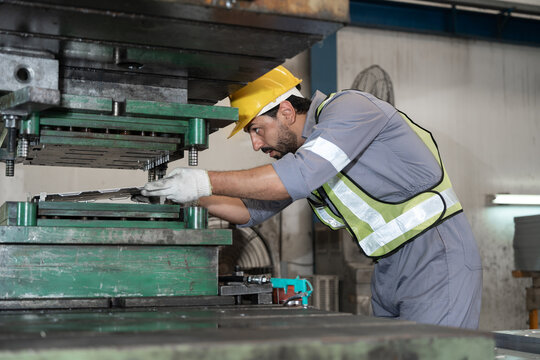 Industrial workers working and control machine at auto parts factory