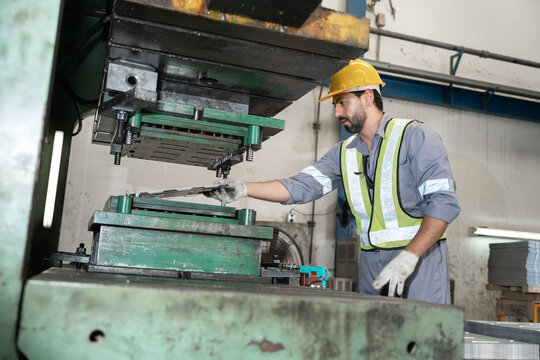 Industrial workers working and control machine at auto parts factory