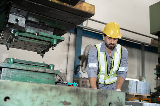 Industrial workers working and control machine at auto parts factory