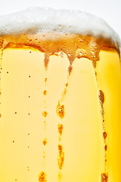Macro Close-Up of Cold Lager Beer with Foam Head and Bubbles in Glass