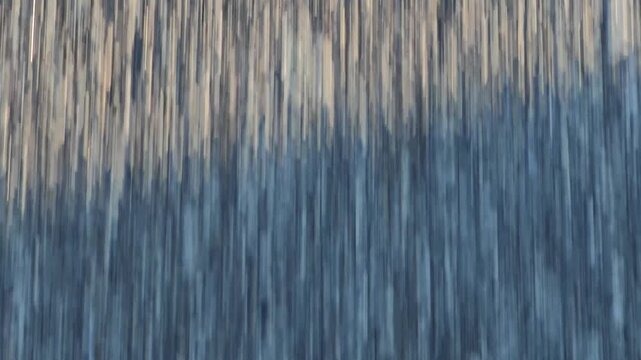 Close view reveals repetitive vertical striped texture across worn surface in muted brown, blue, and gray tones; soft moving blur adds dynamic abstract mood for industrial backdrop and modern design
