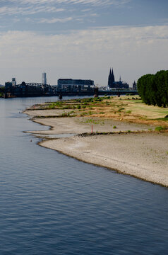 Uferlinie des Rheins bei niedrigen Wasserstand mit Kranh&auml;usern und Dom im Hintergrund