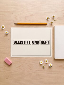 Bleistift und Heft Karte auf Holztisch von oben