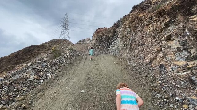 Children hiking along a rocky path up the mountain