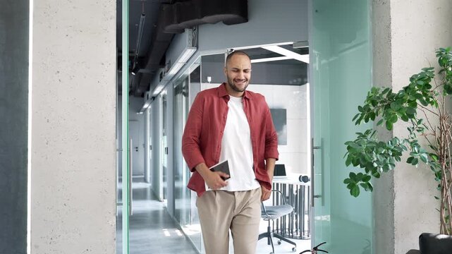 Happy joyful businessman dancing victory dance walking along corridor of modern business center. Male worker cheerfully celebrating achievement. Success and happiness of funny entrepreneur or employee