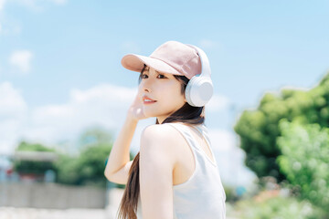 Fototapeta premium 屋外で音楽を聴く若い女性