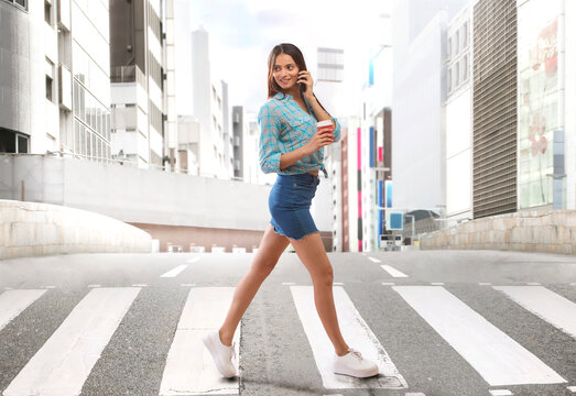 Young woman walking on zebra crossing