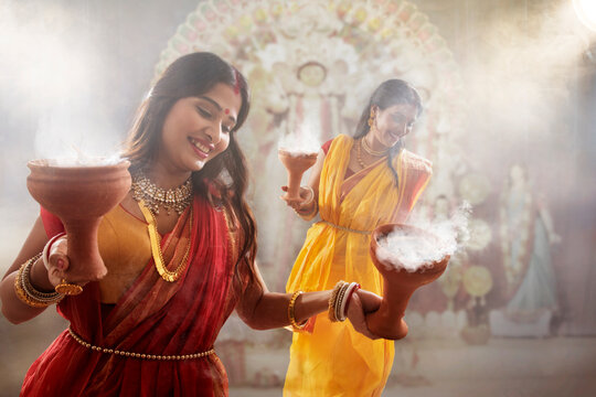 Two bengali women performing dhunuchi dance on the occasion of durga puja