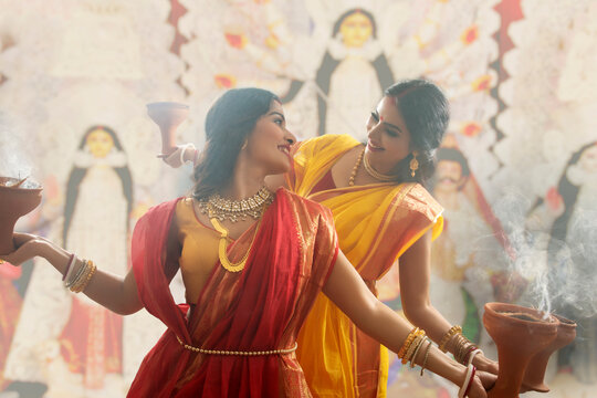 Two Married bengali women performing dhunuchi dance on the occasion of durga puja