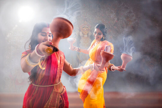 Two Married bengali women performing dhunuchi dance on the occasion of durga puja