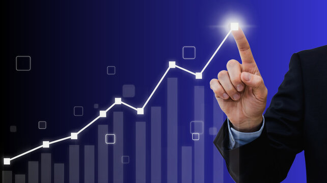 Businessman pointing at a glowing financial growth chart representing success, strategy, and business development