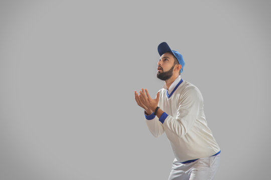 Fielder waiting to catch a ball on grey background