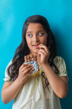 Girl eating chocolate looking away