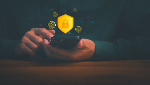 Adult man uses a smartphone with a glowing shield and lock icon for cybersecurity. This advanced digital technology ensures strict internet privacy, mobile data protection, and secure online security.