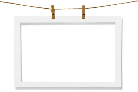Blank photo frame hanging on a rope with a wooden clothespin. Isolated transparent PNG mockup.