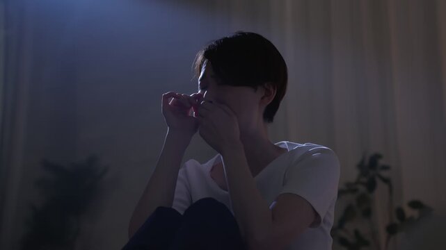 夜中に部屋で落ち込む女性