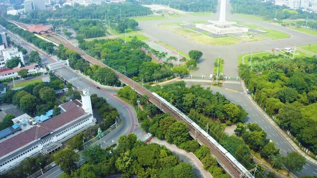 Aerial View of Commuter Train Passing Monas Monument and Gambir Area in Jakarta