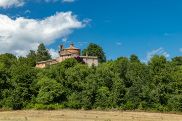 Obraz premium Rotonda di Montesiepi chapel rising above Tuscan landscape