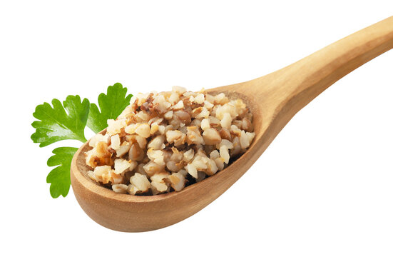 Boiled buckwheat in a wooden spoon with a parsley leaf on a white background. Isolated