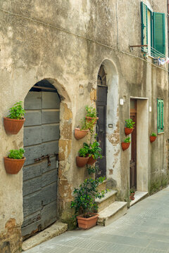 Old town alley in Pitigliano with rustic doorways and potted plants