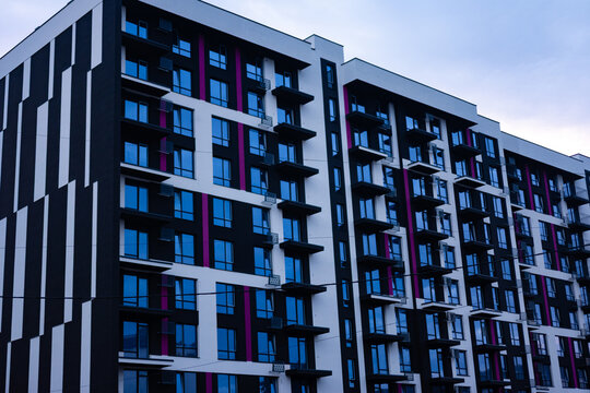 Unique architectural design showcases a striking modern building against a moody sky in an urban landscape during twilight hours